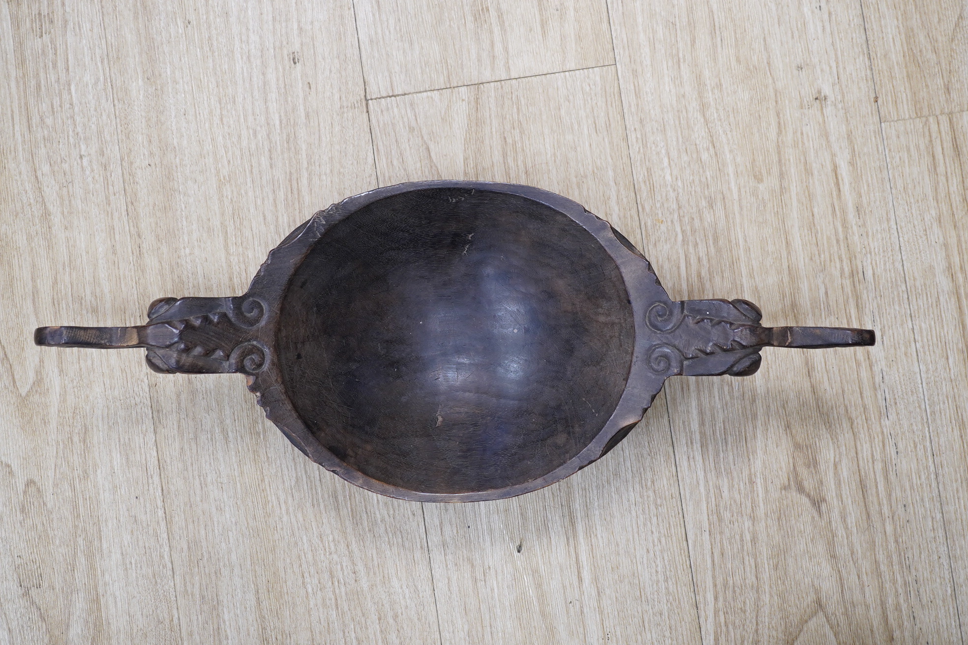 A carved South East Asian bowl, diameter 22cm, overall length 51.5cm. Condition - fair to good